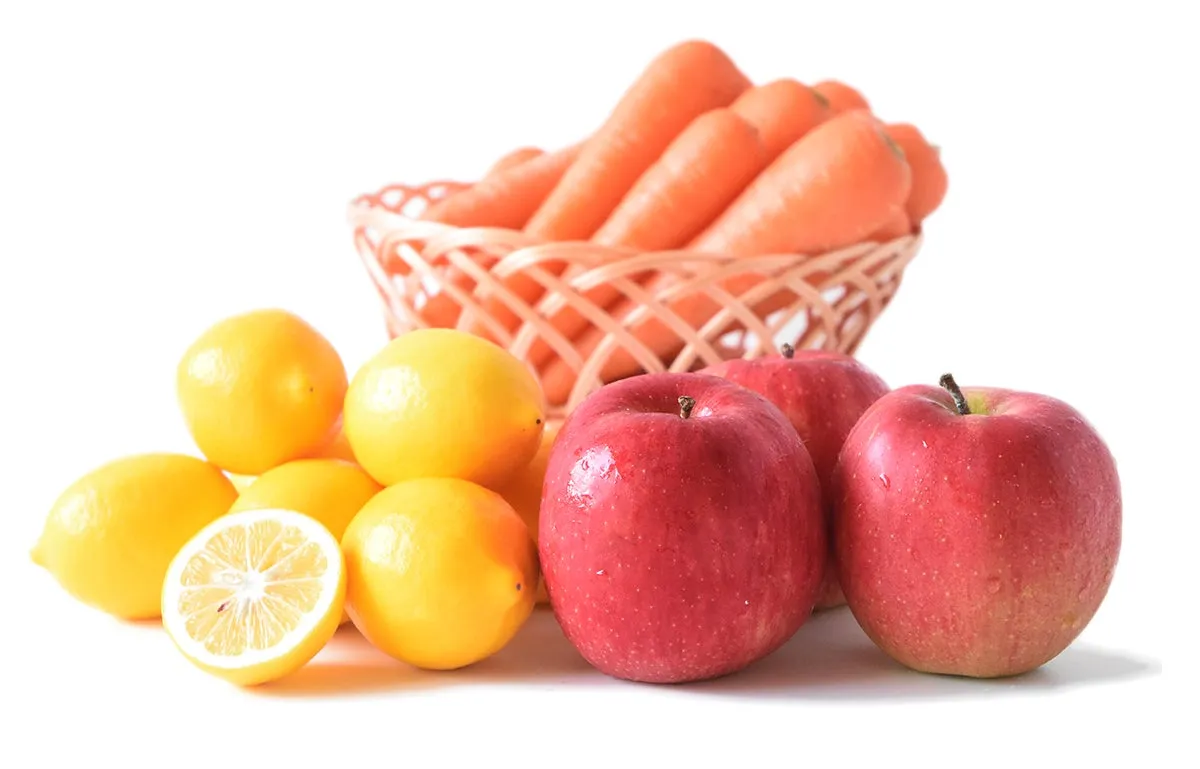 レモンとリンゴとニンジンが盛られたバスケットの画像です。