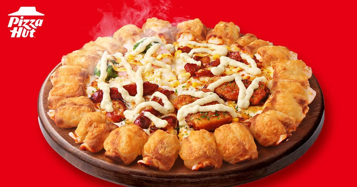 ピザハットのピザのクローズアップ写真。ピザには、トッピング、ソース、揚げ物などが載っている。