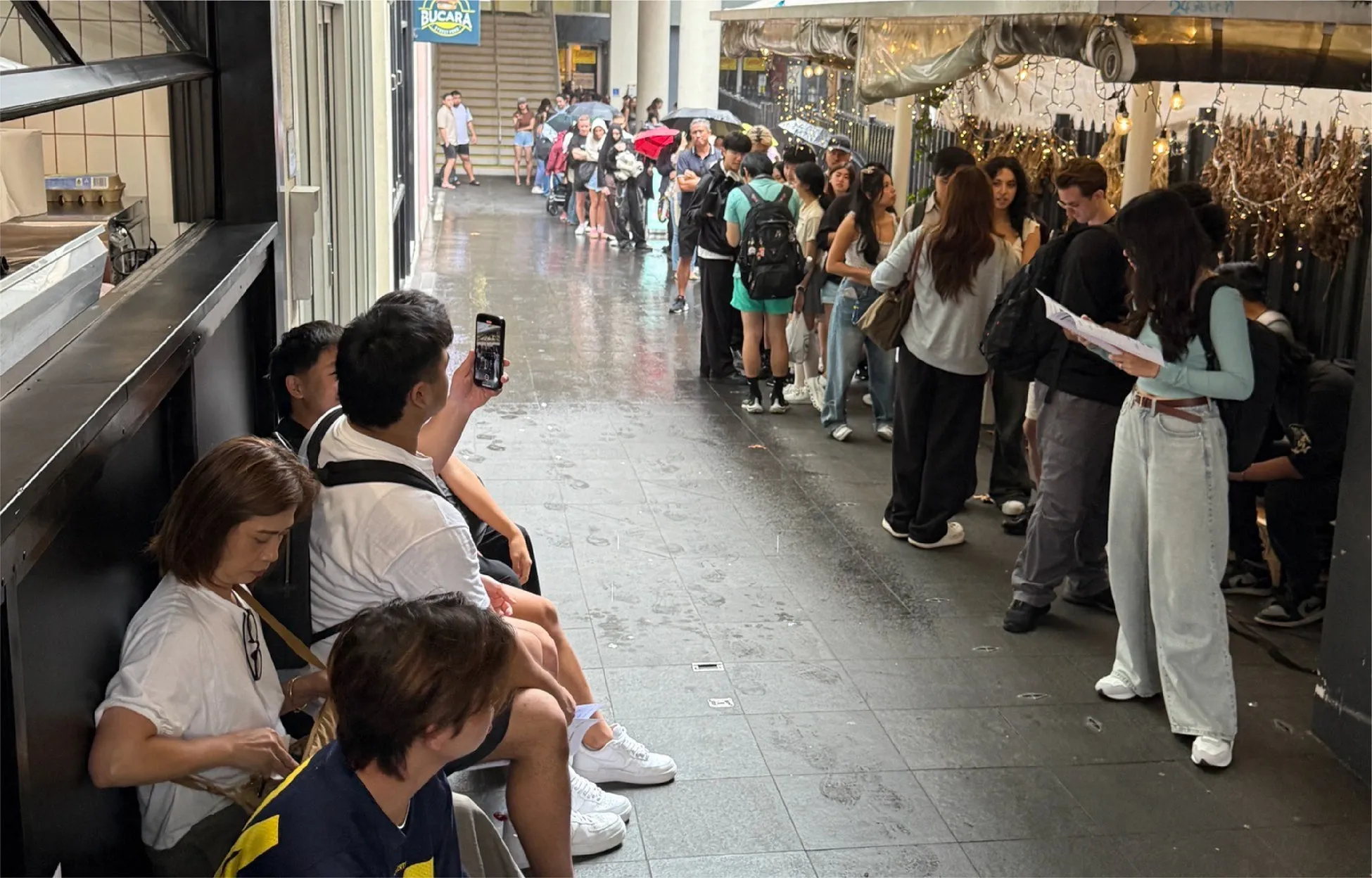 雨の中並ぶ人々