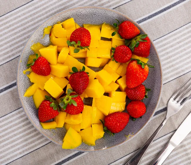 マンゴーとイチゴが乗ったお皿の俯瞰写真。