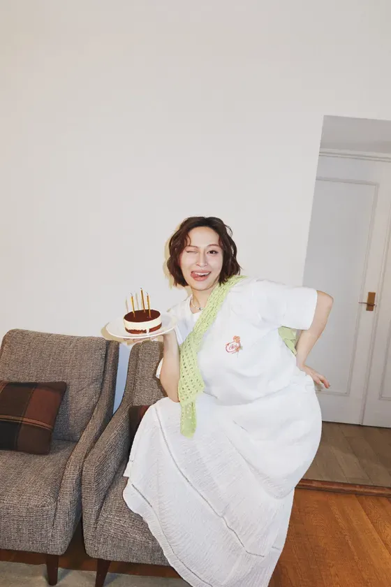 ケーキを持った女性がウィンクをしていて、楽しそうな様子が写っています。