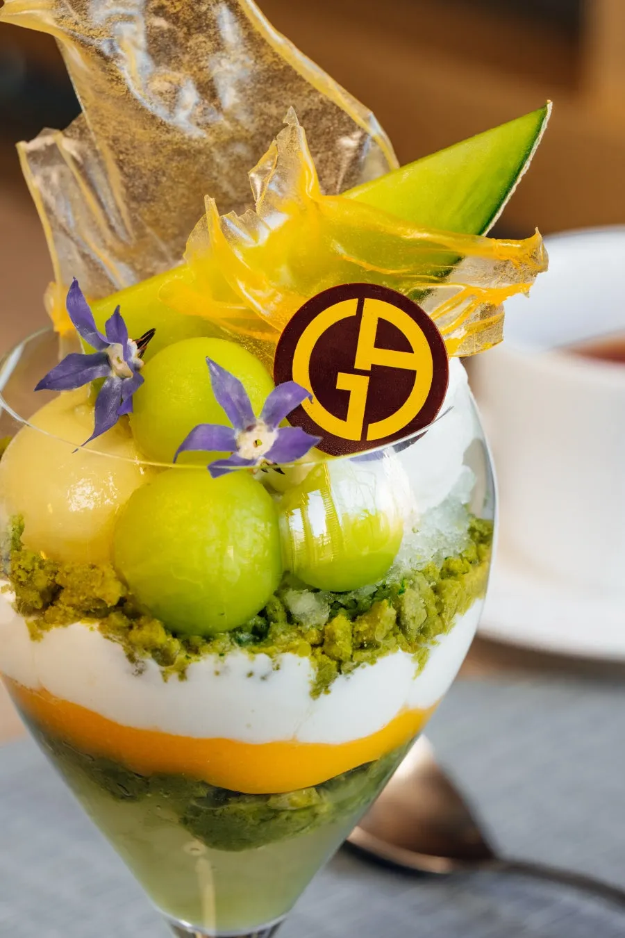 メロン、クリーム、花が飾られたパフェのクローズアップ