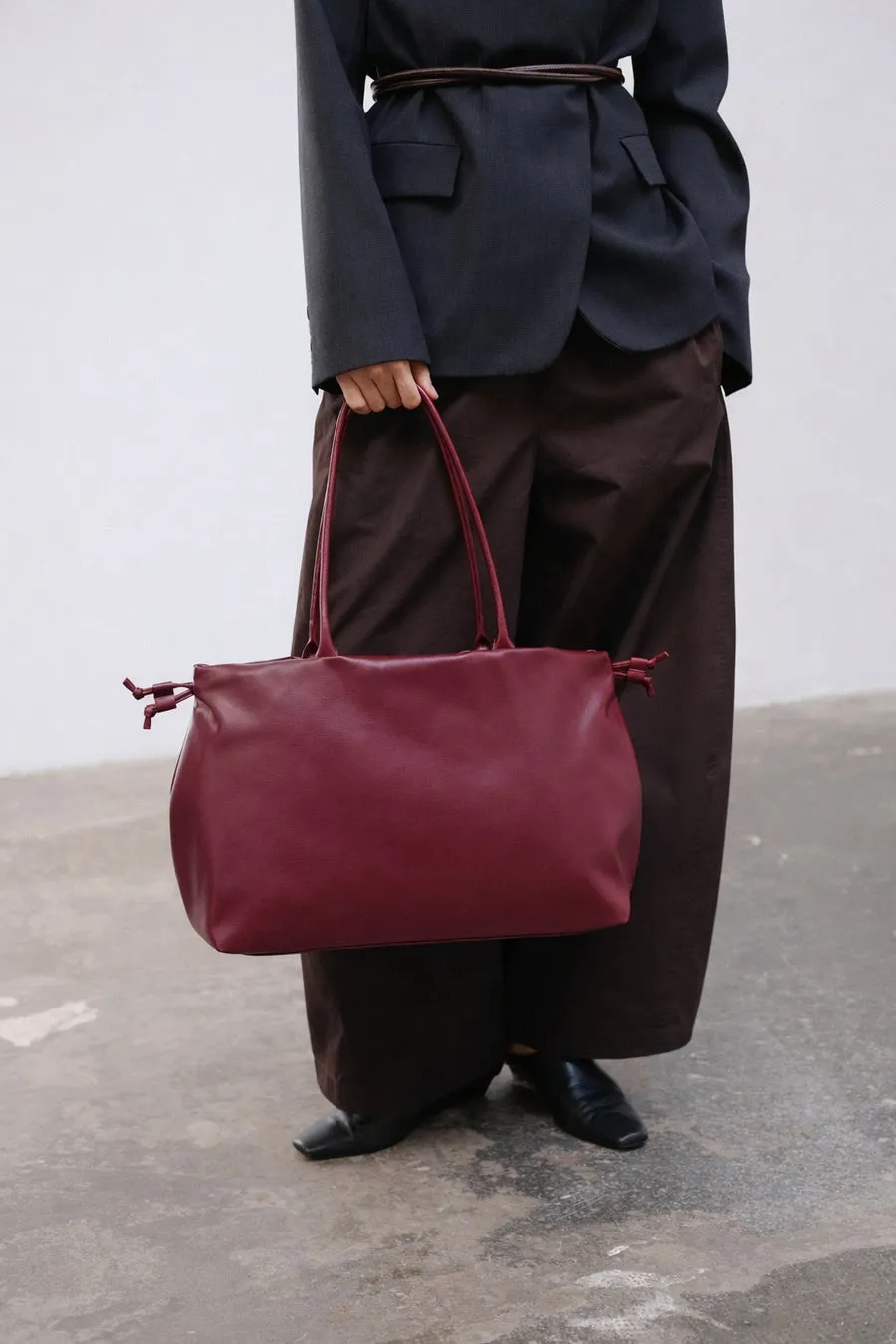 ワインレッドのトートバッグを持った女性