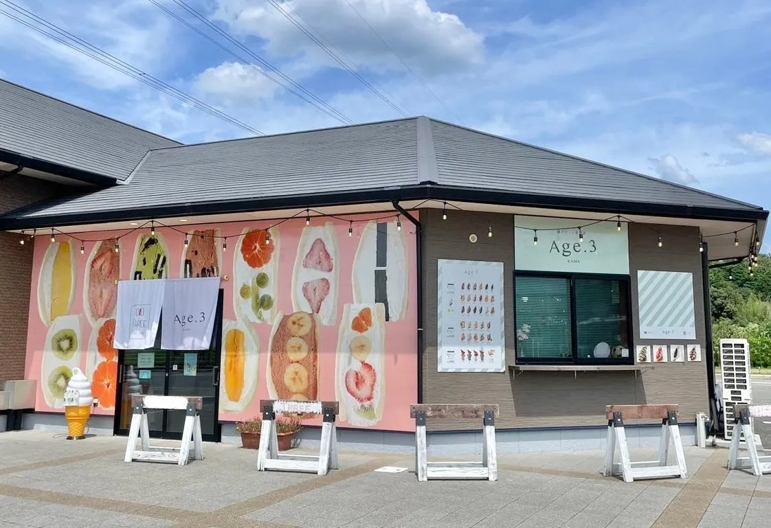 お店の外観の写真。ピンク色の壁にフルーツサンドのイラストが描かれ、Age.3というお店の看板があります。