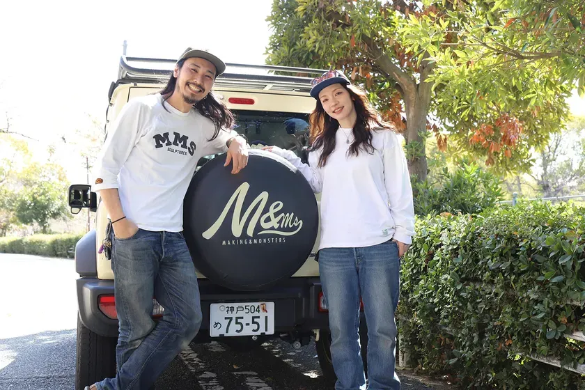 男性と女性が車の後ろに立って笑顔でポーズをとっている写真