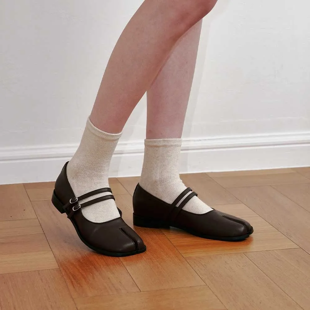 茶色の足袋シューズと白い靴下を履いた女性の足のクローズアップ