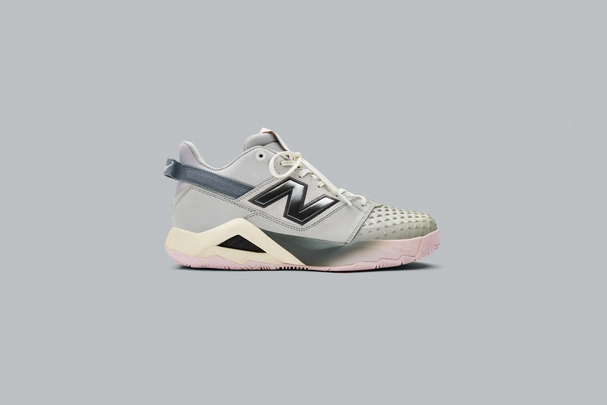 ニューバランスのスニーカーの画像です。グレーを基調に、黒とピンクがアクセントになっています。