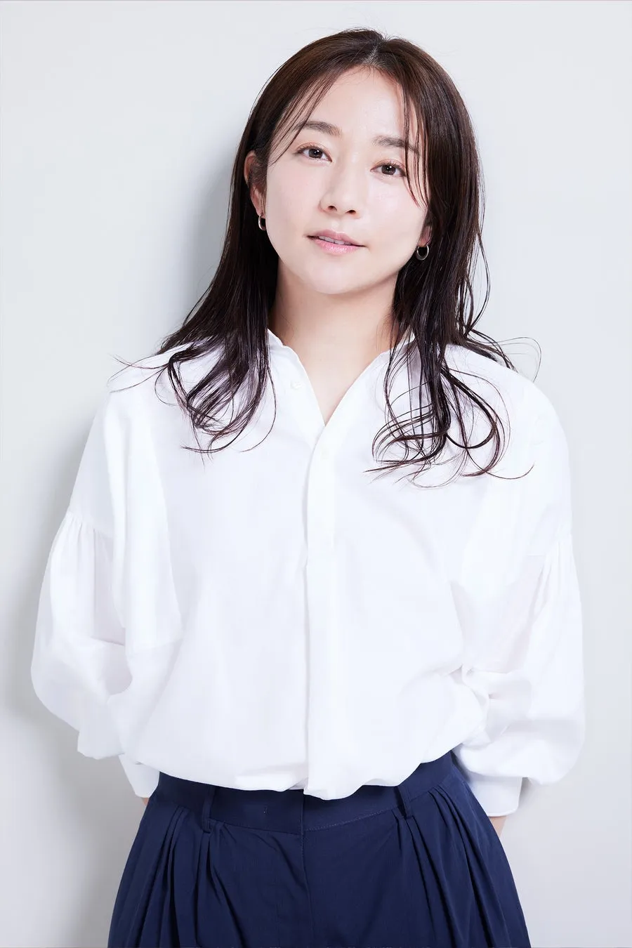 白いシャツと紺色のパンツを着た女性のポートレート。