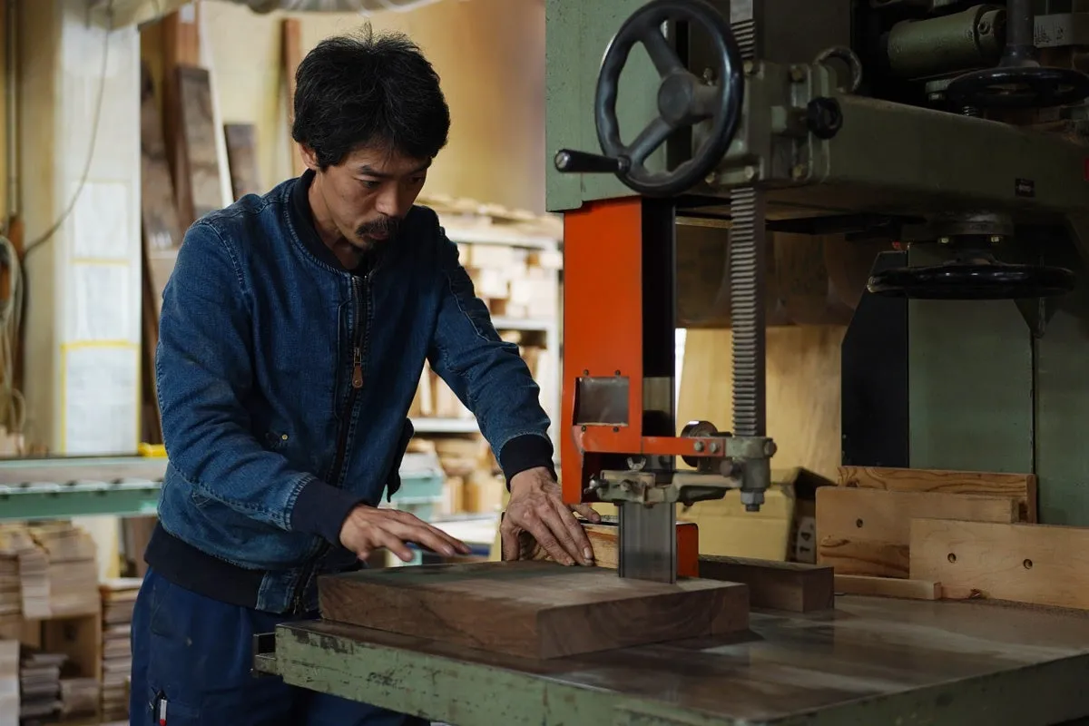 木材加工場で作業をする男性の姿を捉えた写真。