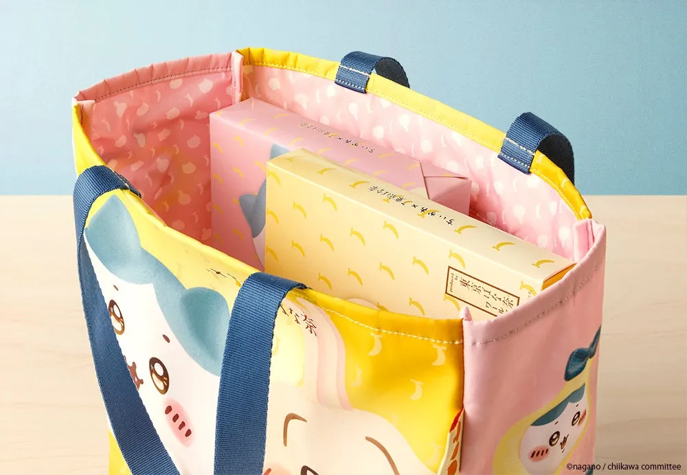 キャラクターが描かれたトートバッグの中に、お菓子が入っている様子を捉えた写真です。バッグはピンクと黄色を基調とし、可愛らしいデザインです。