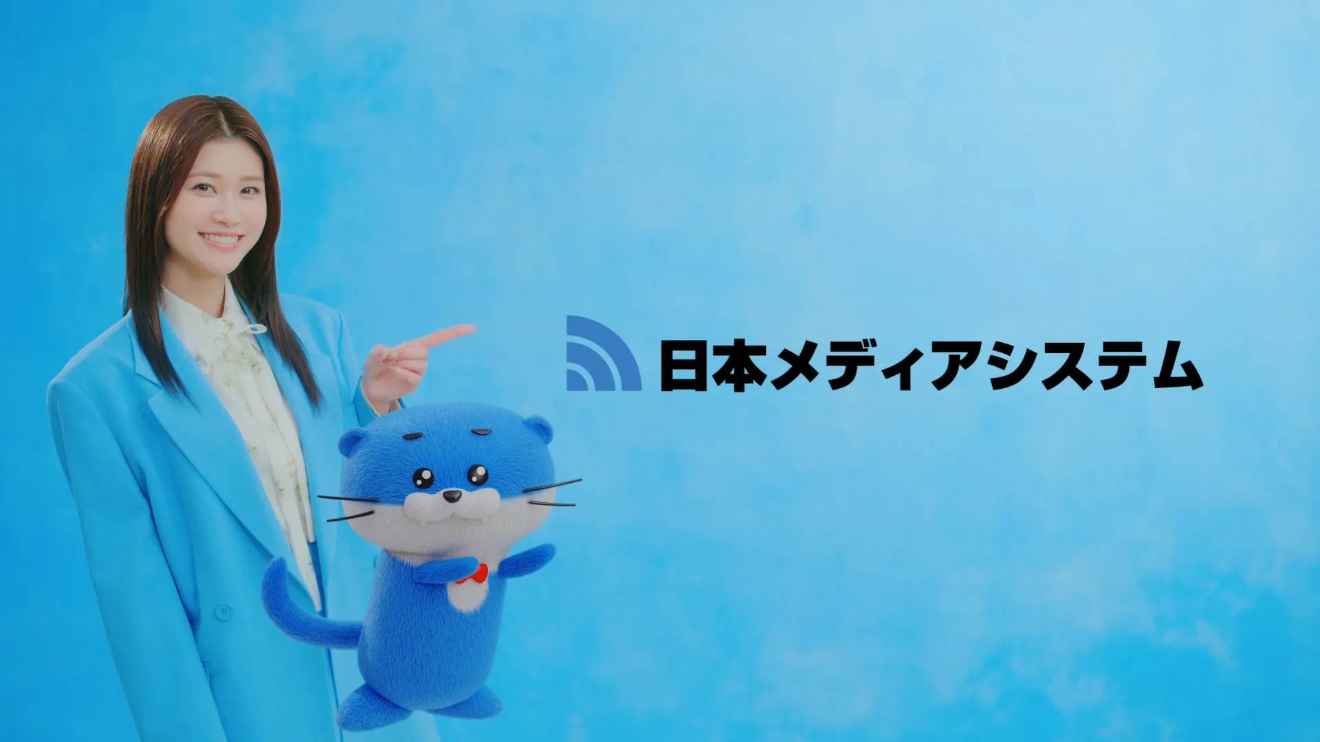女性とキャラクターが写った広告。女性は笑顔で指を指している。