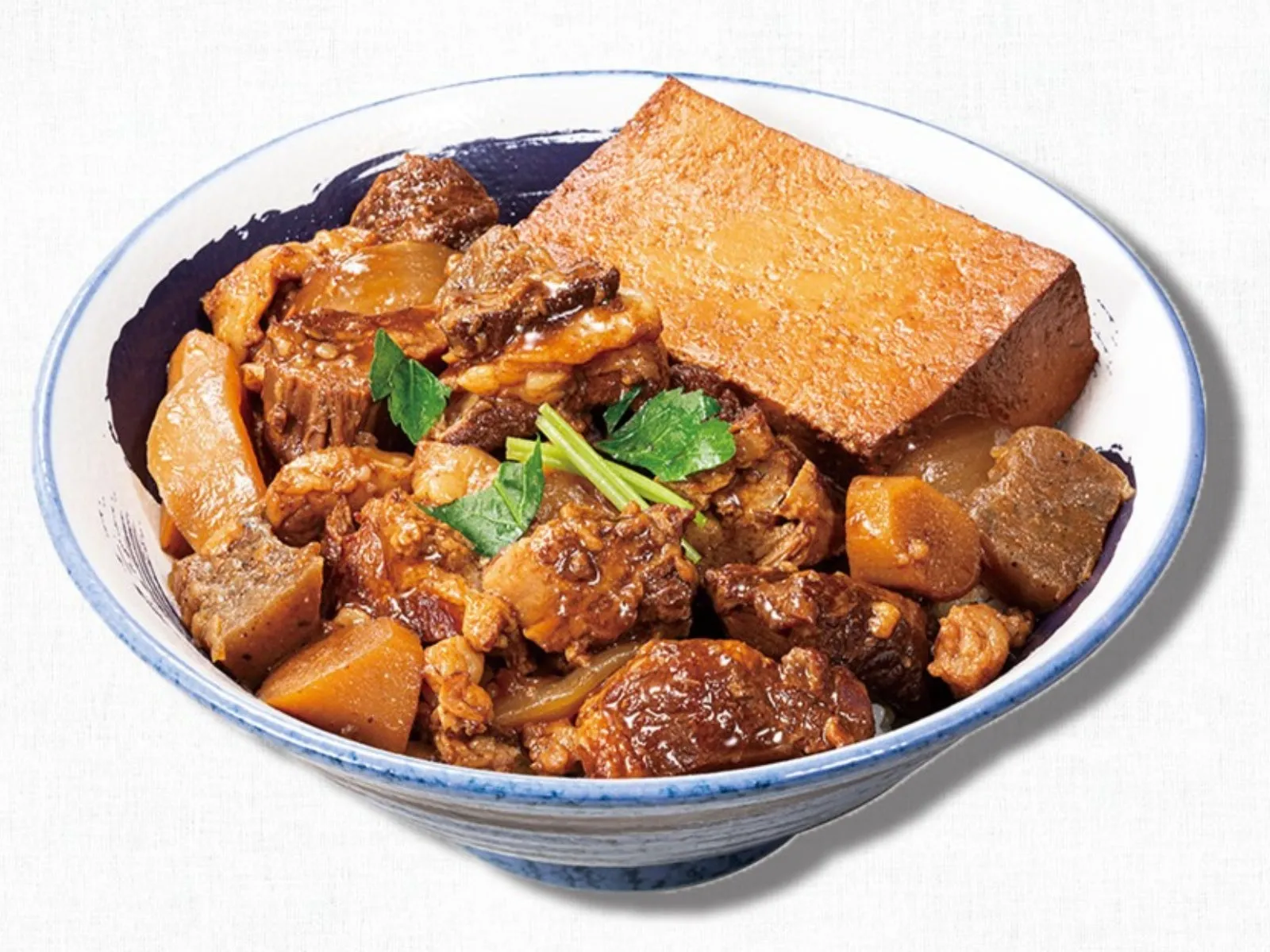 丼に入った角煮と厚揚げの料理の写真です。角煮は大きくカットされており、とろけるような見た目です。厚揚げも大きくカットされていて、食べ応えがありそうです。ネギも添えられており、彩りも豊かです。