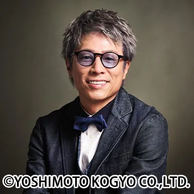 眼鏡をかけた男性が微笑んでいる写真。