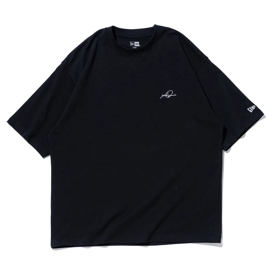 胸元にサインのようなロゴが入った黒Tシャツ