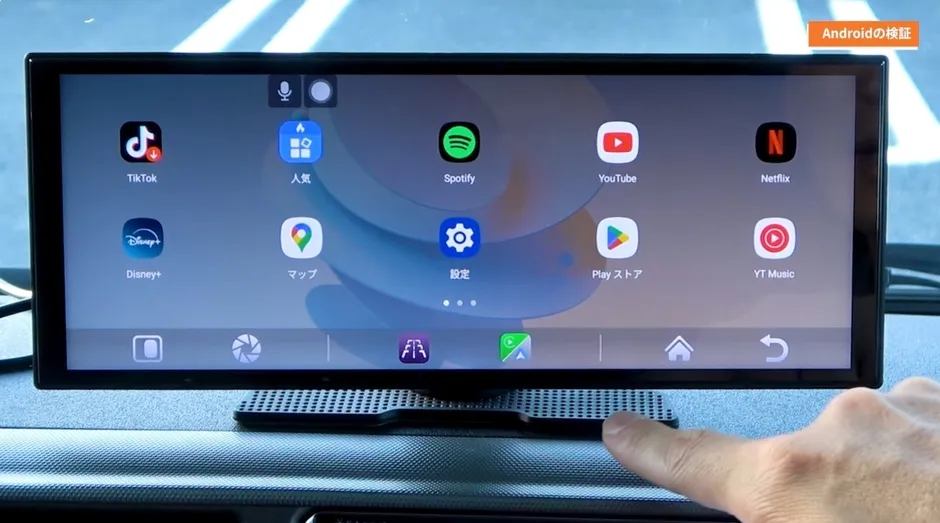車のダッシュボードに設置されたAndroidデバイスの画面。様々なアプリのアイコンが表示されており、TikTok、Disney+、Spotify、YouTube、Netflixなどが確認できる。