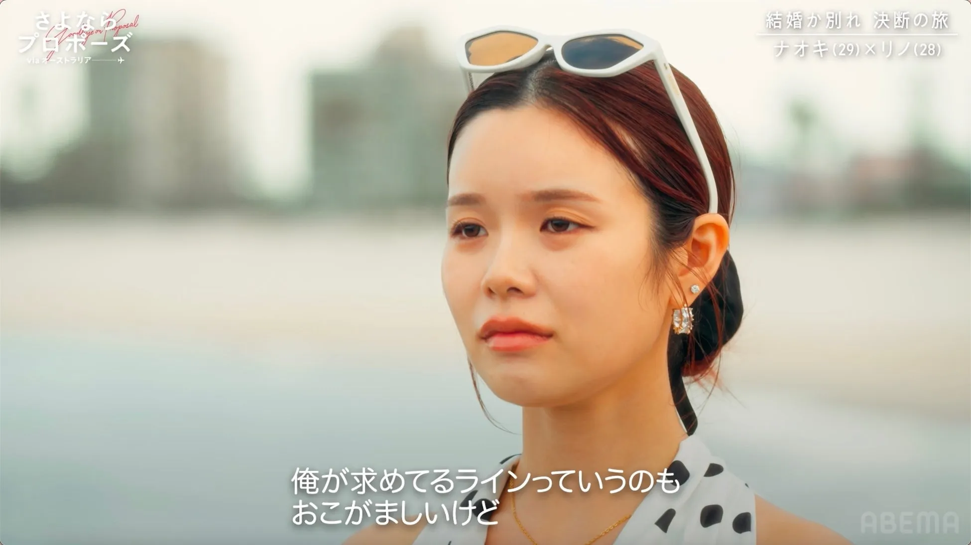 女性が海辺で物思いにふけている様子