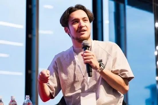 マイクを持ち、講演をしている男性の画像