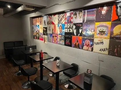 レコードジャケットが壁に飾られたバーの店内