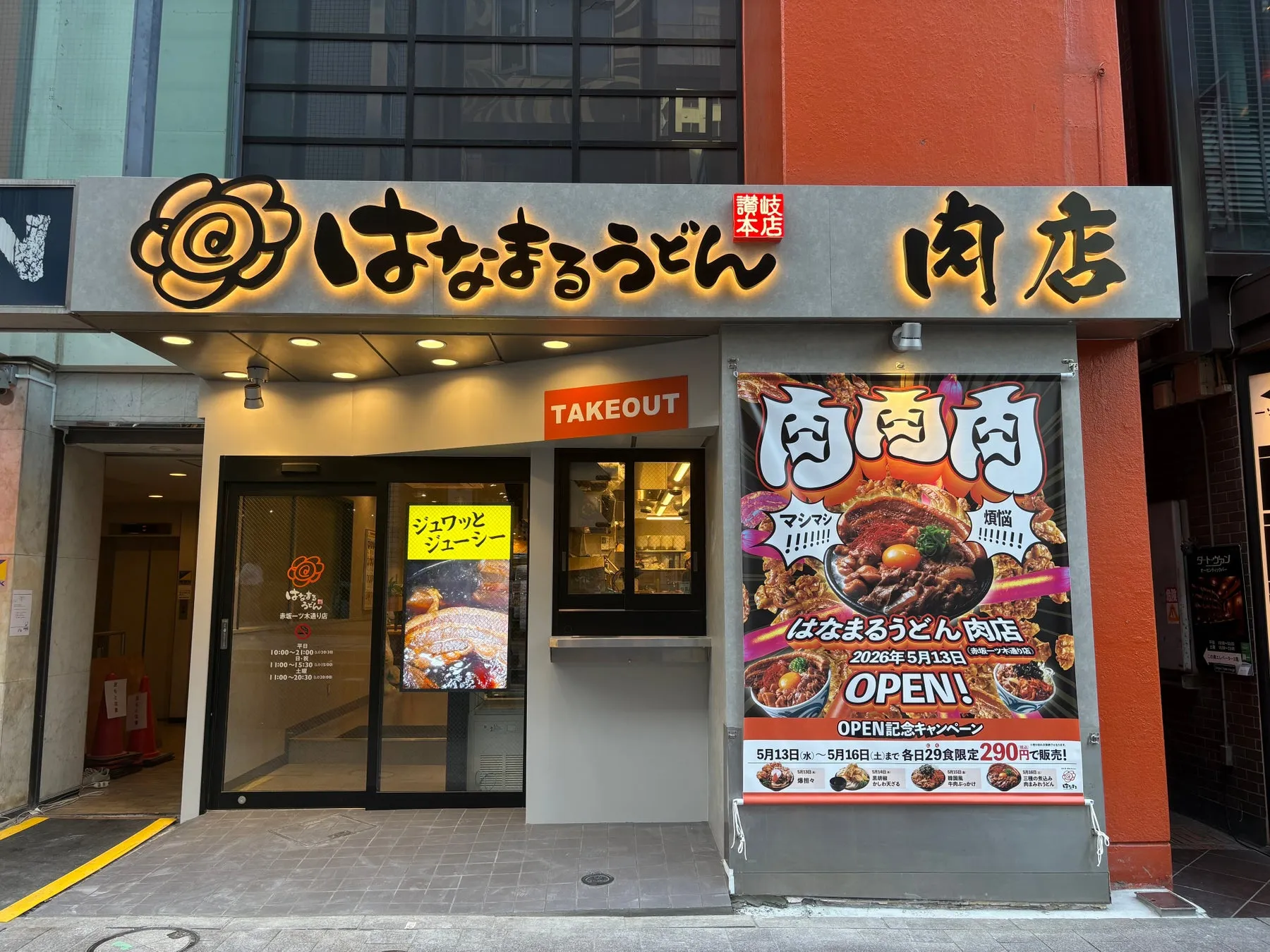 うどん屋の店舗の外観。看板には「はなまるうどん 肉店」と書かれており、オープン記念キャンペーンのポスターも掲示されている。