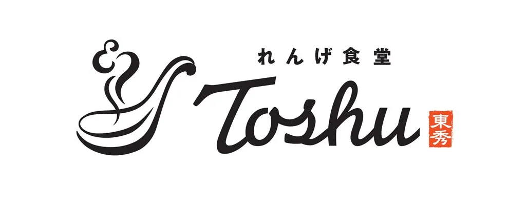 白地に黒文字で「れんげ食堂 Toshiu 東秀」と書かれたロゴ。左上に装飾的な曲線があり、右側に「Toshiu」の筆記体文字、その上に日本語、右下に漢字のマークがある。