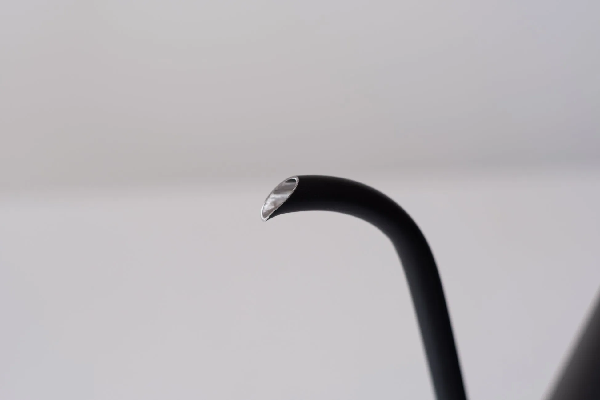 黒いケトルの一部が写った写真。注ぎ口の金属部分が光っている。