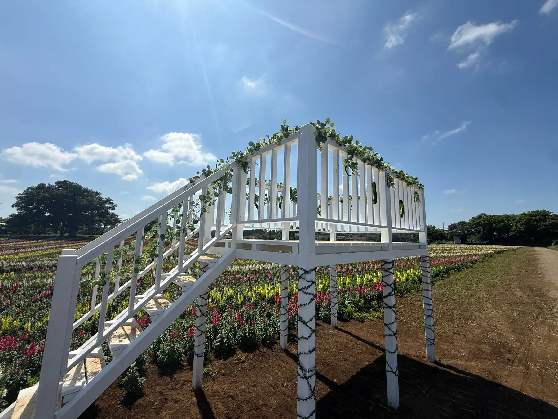 白い展望台がある花の咲き乱れる公園の風景