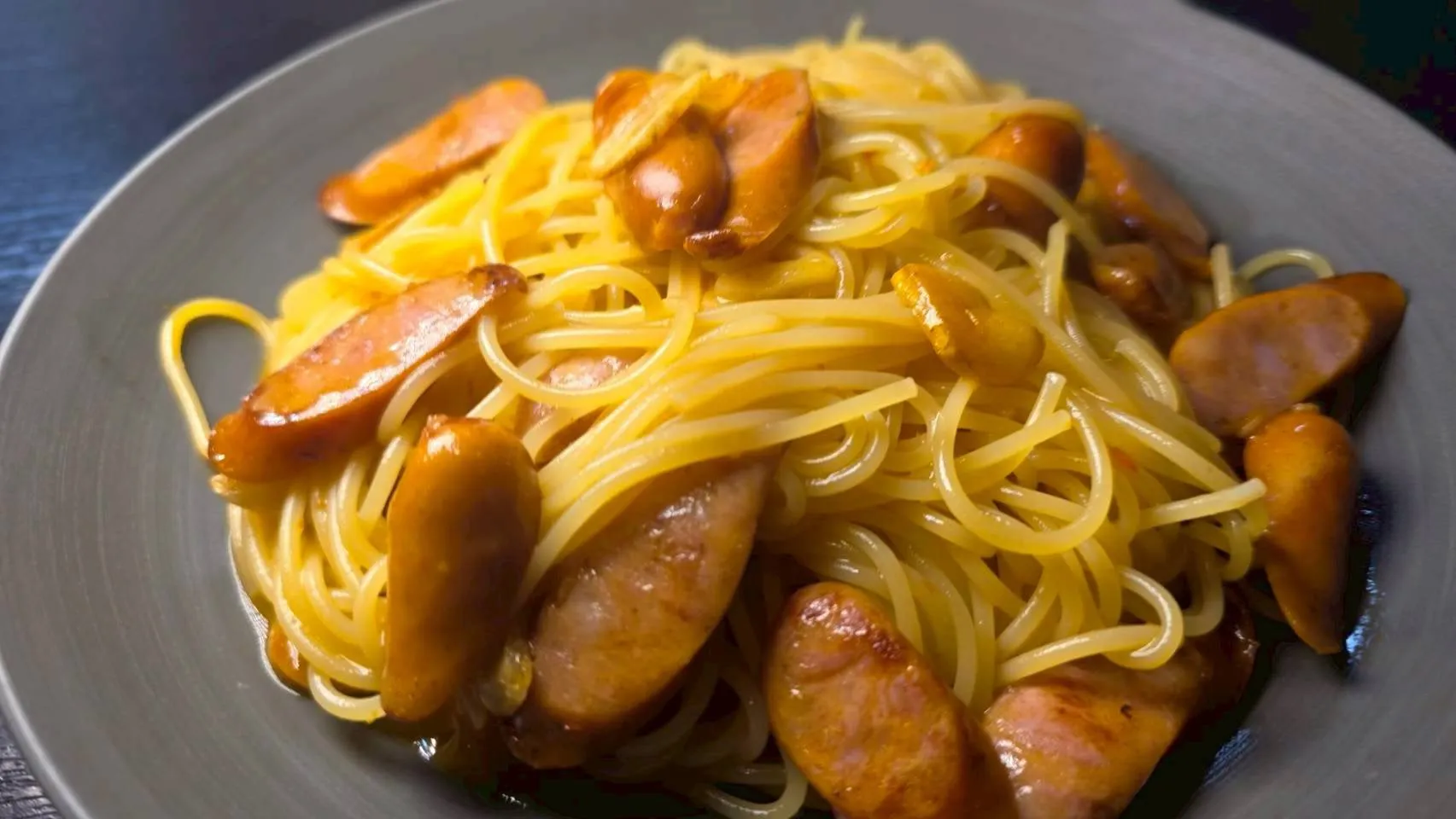 お皿に盛られたソーセージとパスタのクローズアップ写真です。