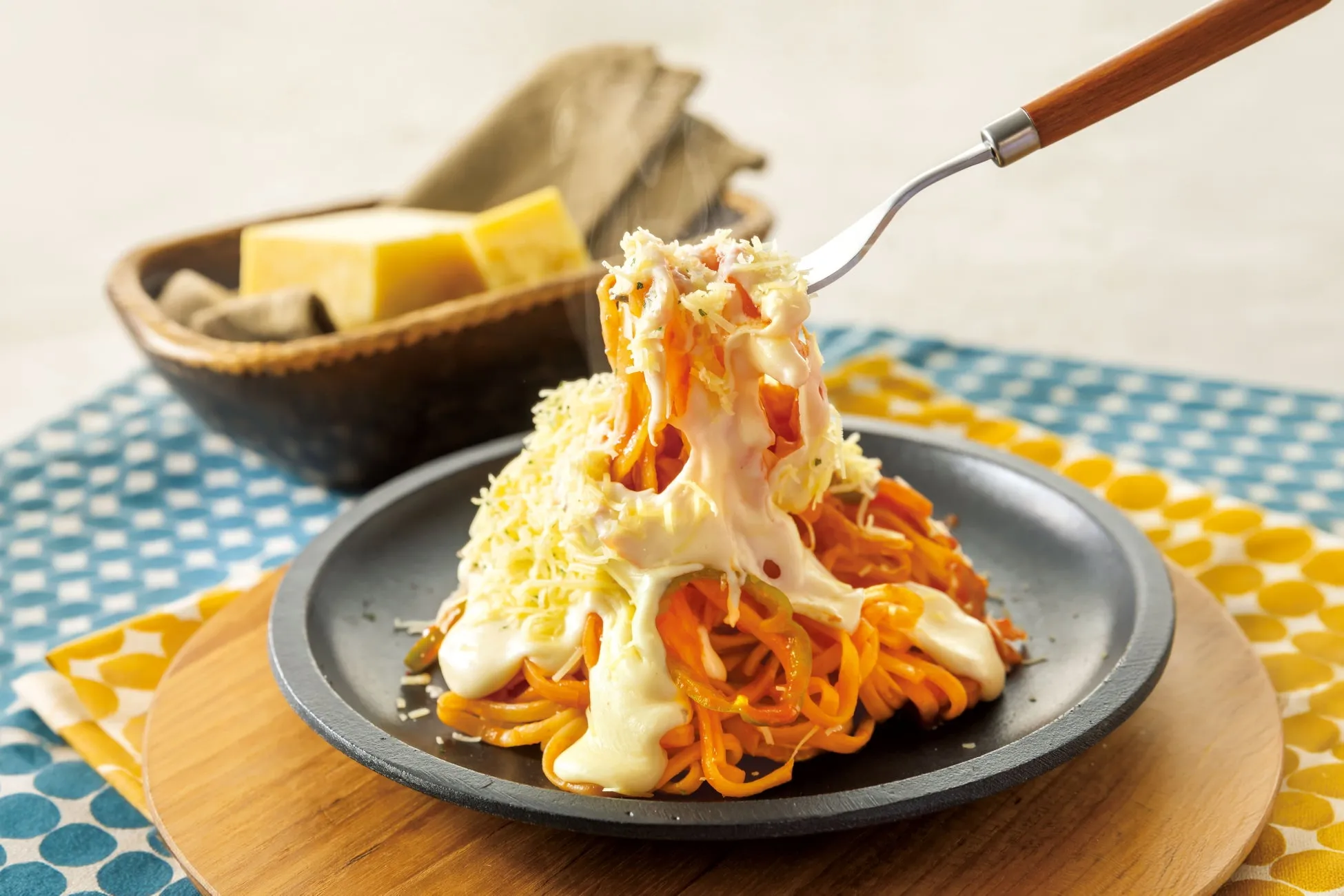 チーズとソースがかかったオレンジ色の麺料理