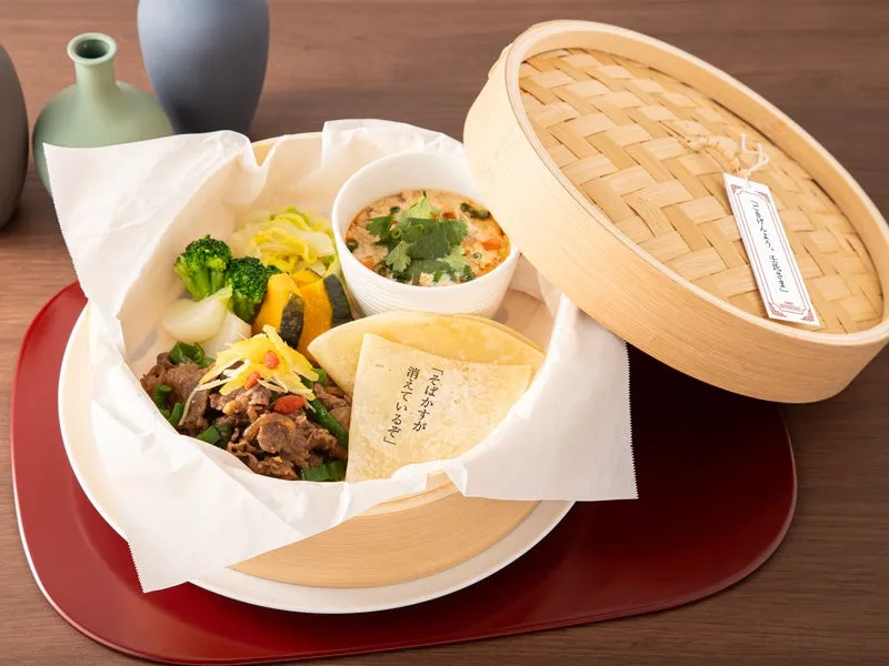 蒸籠に入った料理の写真。野菜や肉、スープ、クレープのようなものが入っている。そばかすが消えているぞと書かれた紙が添えられている。