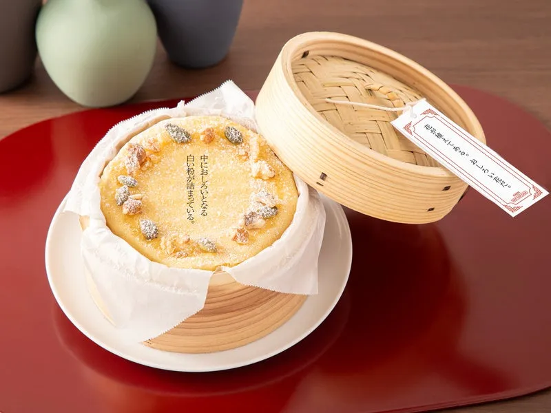 蒸籠に入った、白い粉がまぶされたお菓子。蓋にはメッセージが書かれたタグが添えられている。