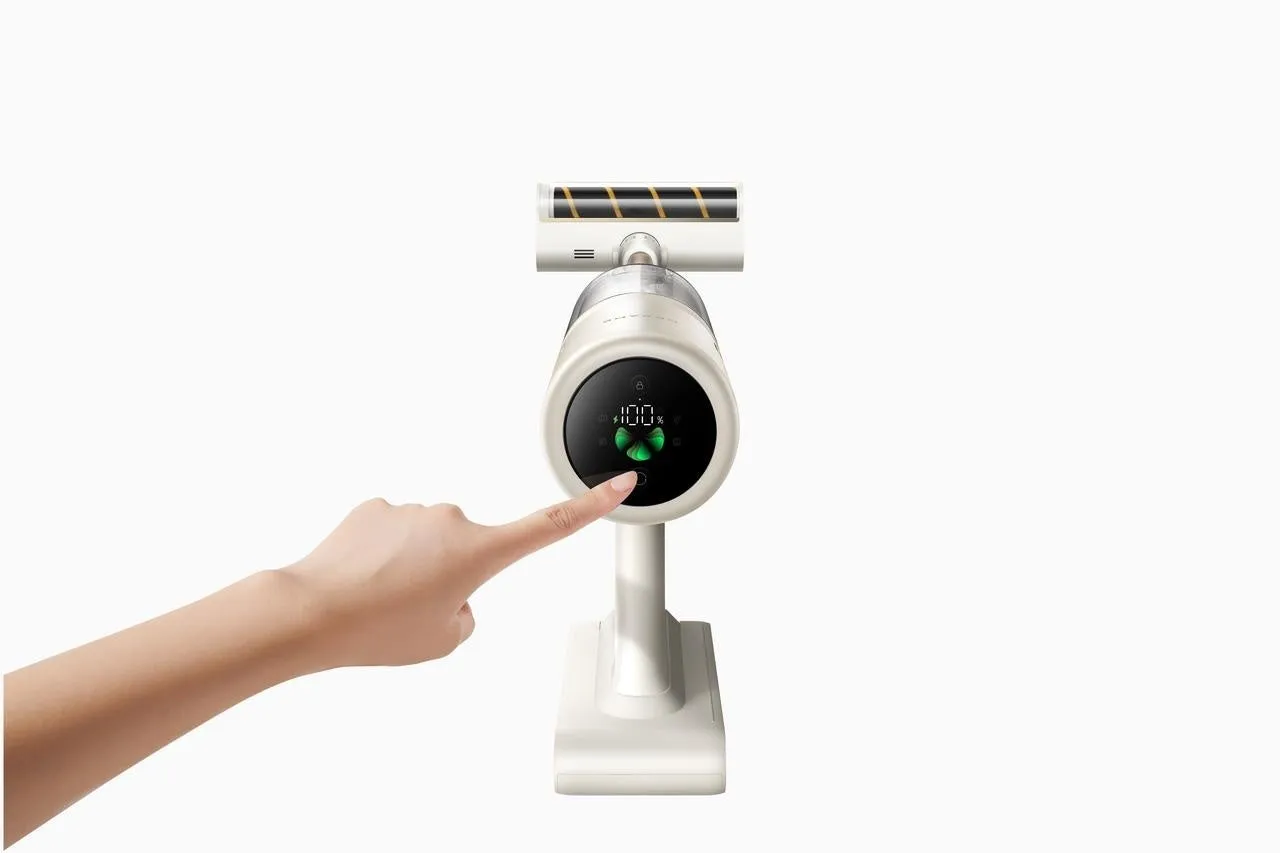 白を基調とした掃除機と、掃除機のボタンを押す手の画像です。