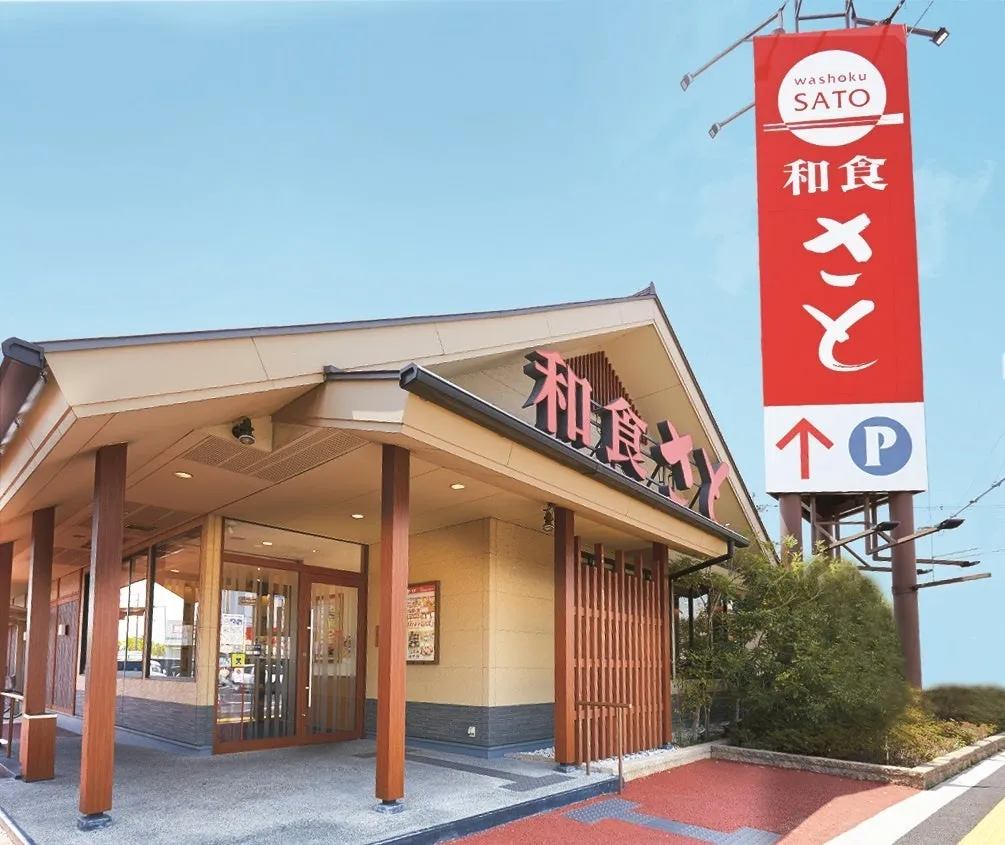 和食レストラン「さと」の外観。赤い看板が目印で、駐車場への案内表示もある。