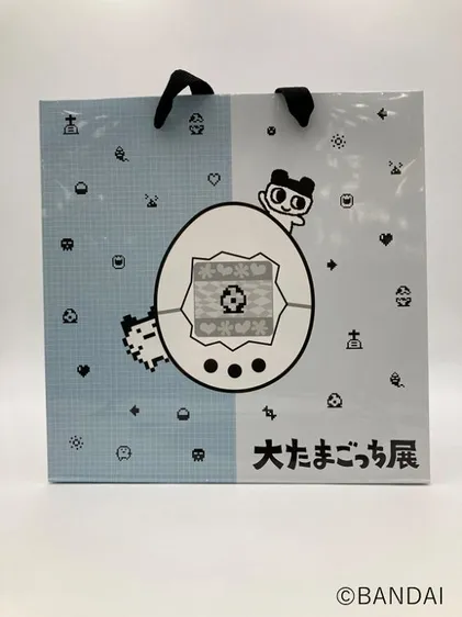 たまごっちのキャラクターが描かれた青いショッパー