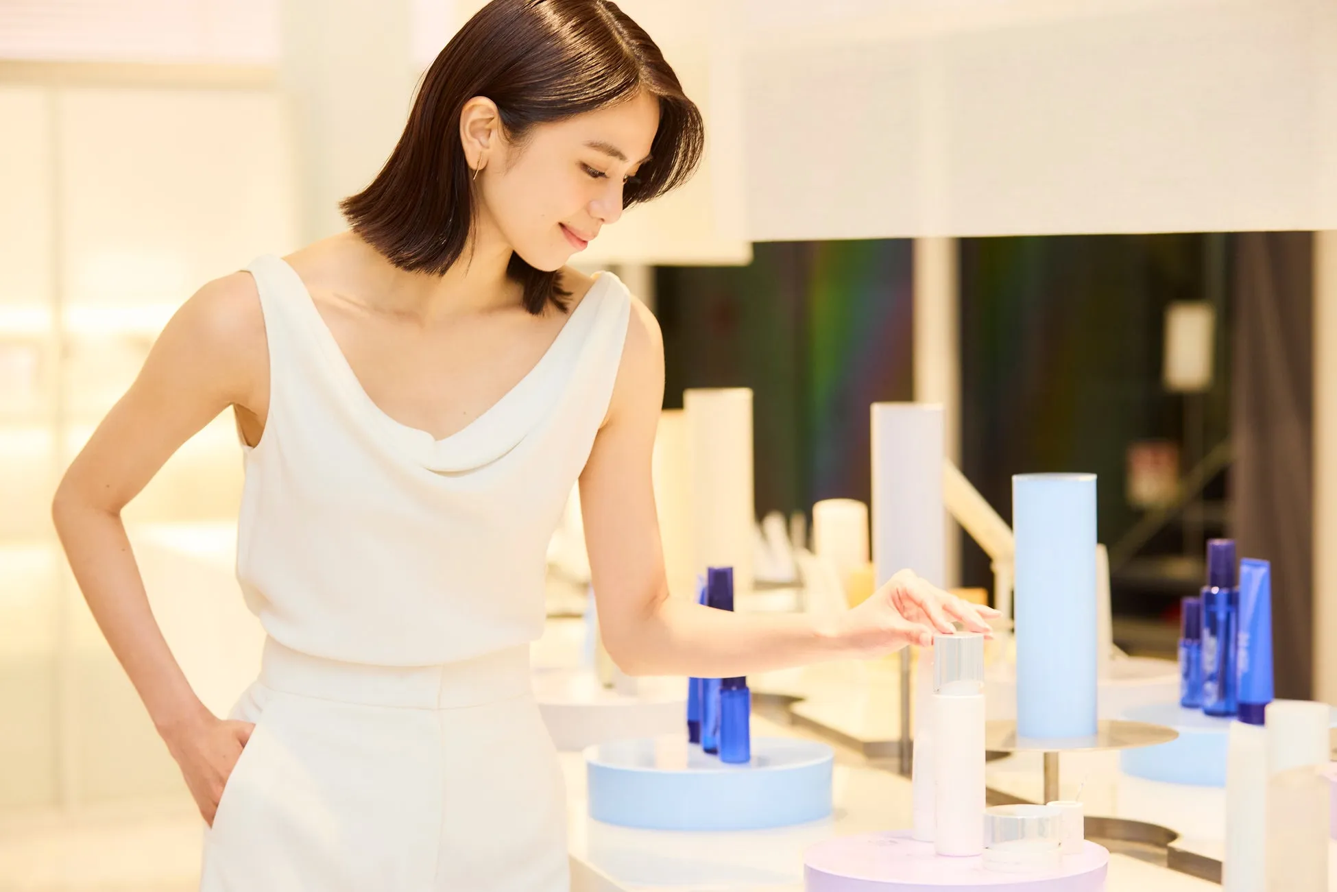女性が化粧品売り場で商品を選んでいる様子