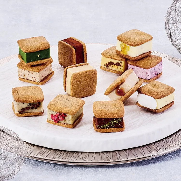 様々なフレーバーのクッキーサンドが白い皿に並べられた写真です。抹茶、チョコレート、フルーツなど、様々な具材が使われています。