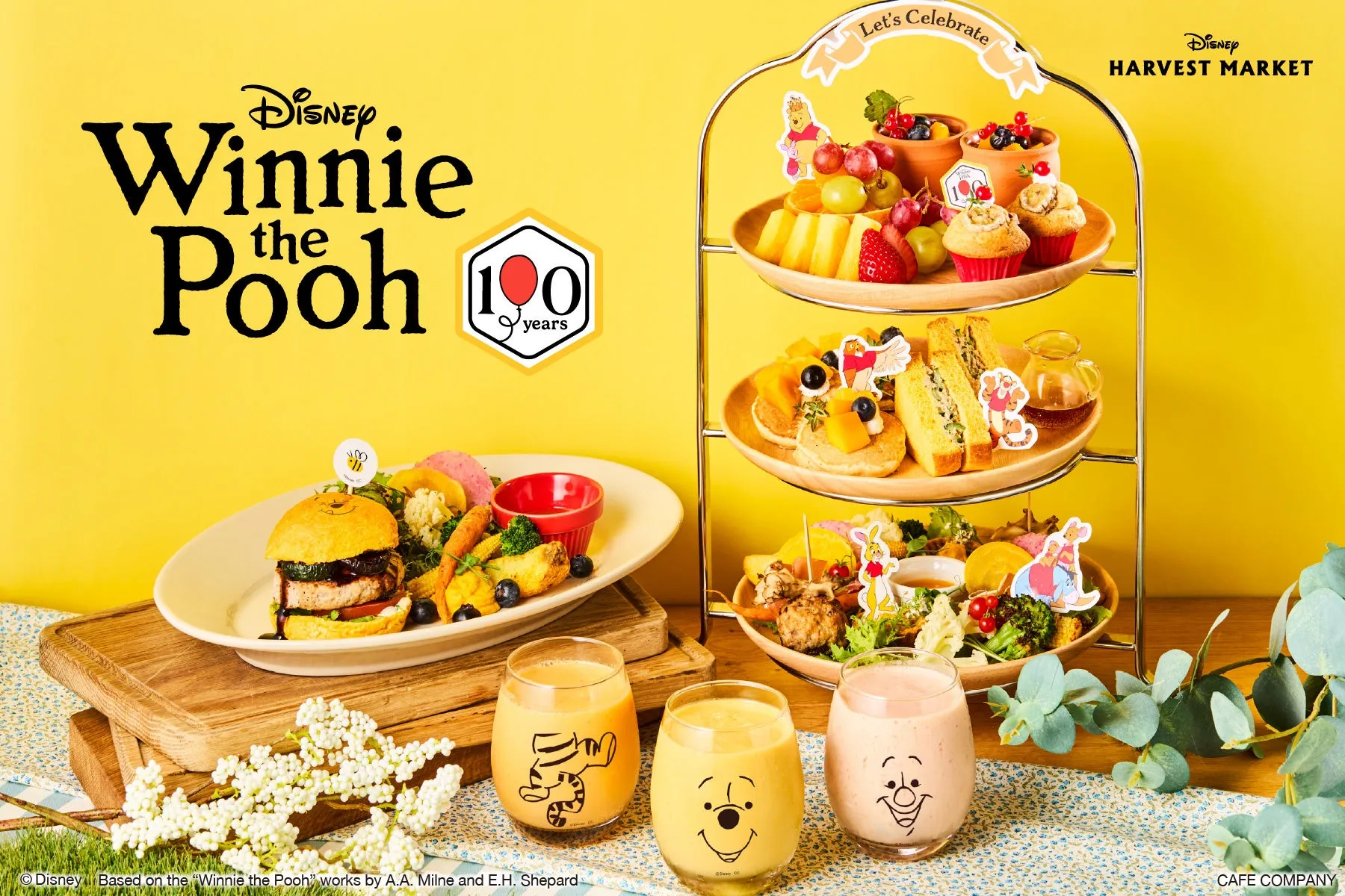 ディズニーのくまのプーさんの100周年を記念したカフェのメニューを紹介する写真です。プーさんをイメージしたドリンクや、キャラクターをモチーフにした料理が並んでいます。