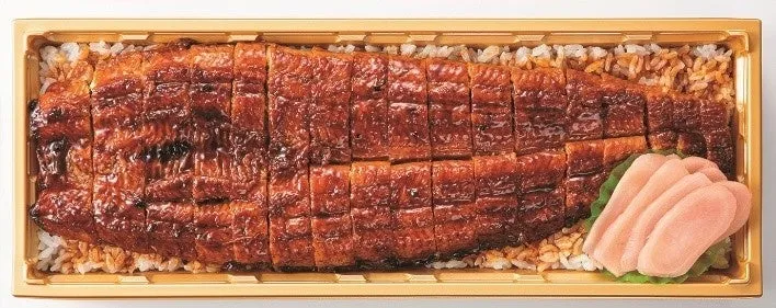 うなぎの蒲焼きが乗った弁当の写真です。ご飯の上には蒲焼きが綺麗に並べられ、横には紅生姜が添えられています。