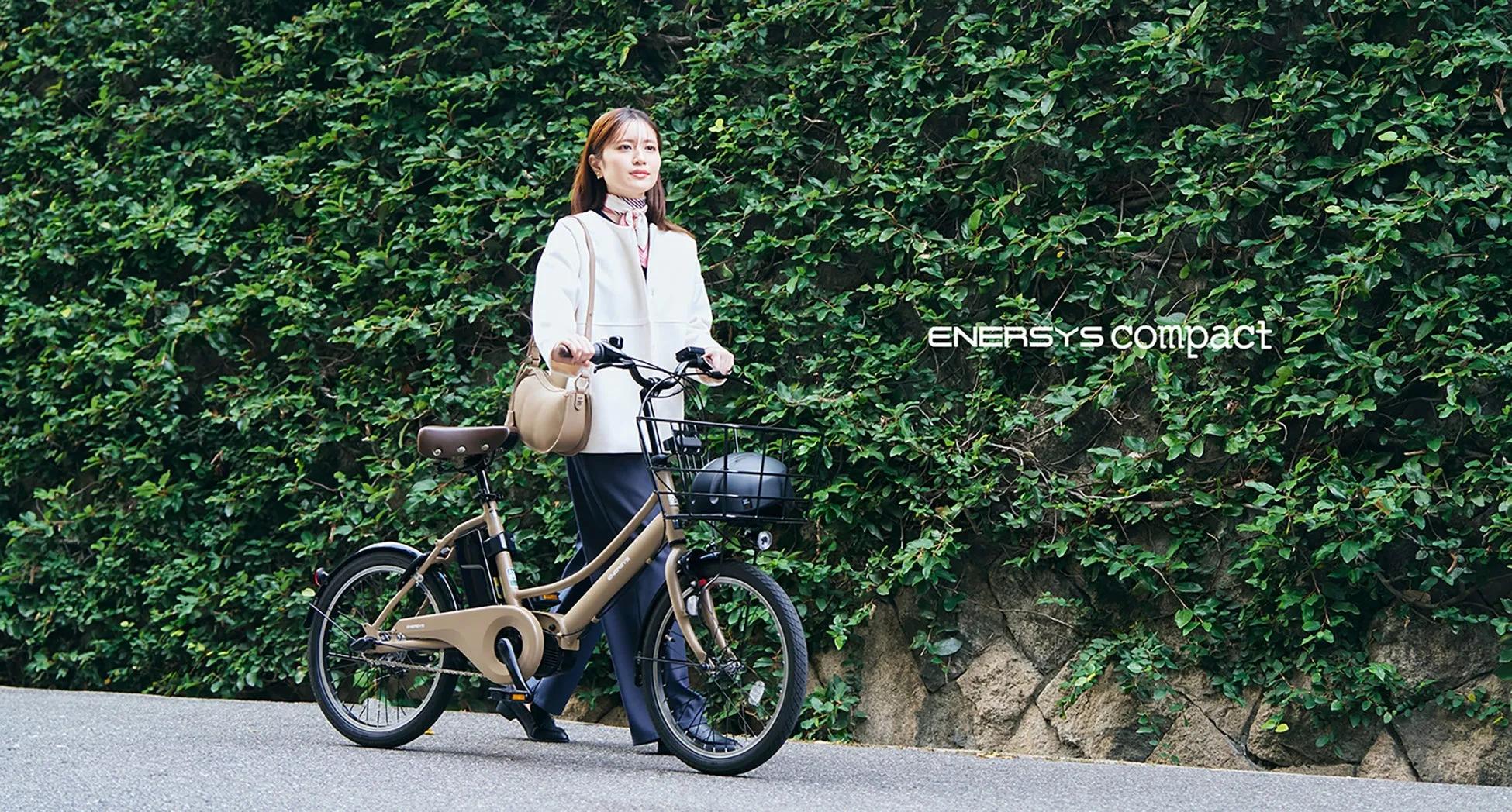 女性が電動アシスト自転車を押して歩いている様子