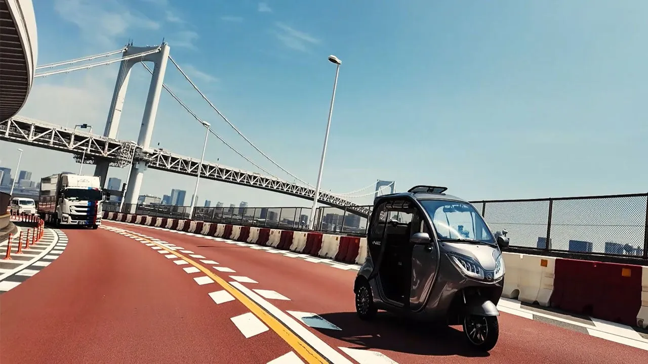 レインボーブリッジを走行する電気自動車とトラックの風景。