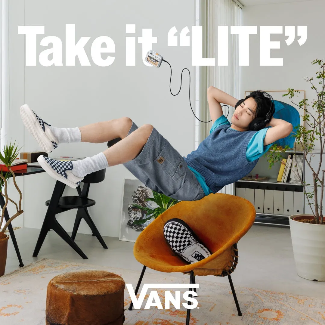 リラックスした男性がヘッドホンをして音楽を聴きながらVANSのスニーカーを履いてくつろいでいる画像。