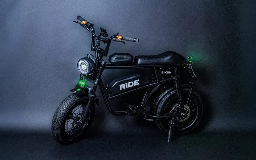 黒い電動バイクのスタジオショット。バイクは黒色で、RIDEとE-KONのロゴが入っている。