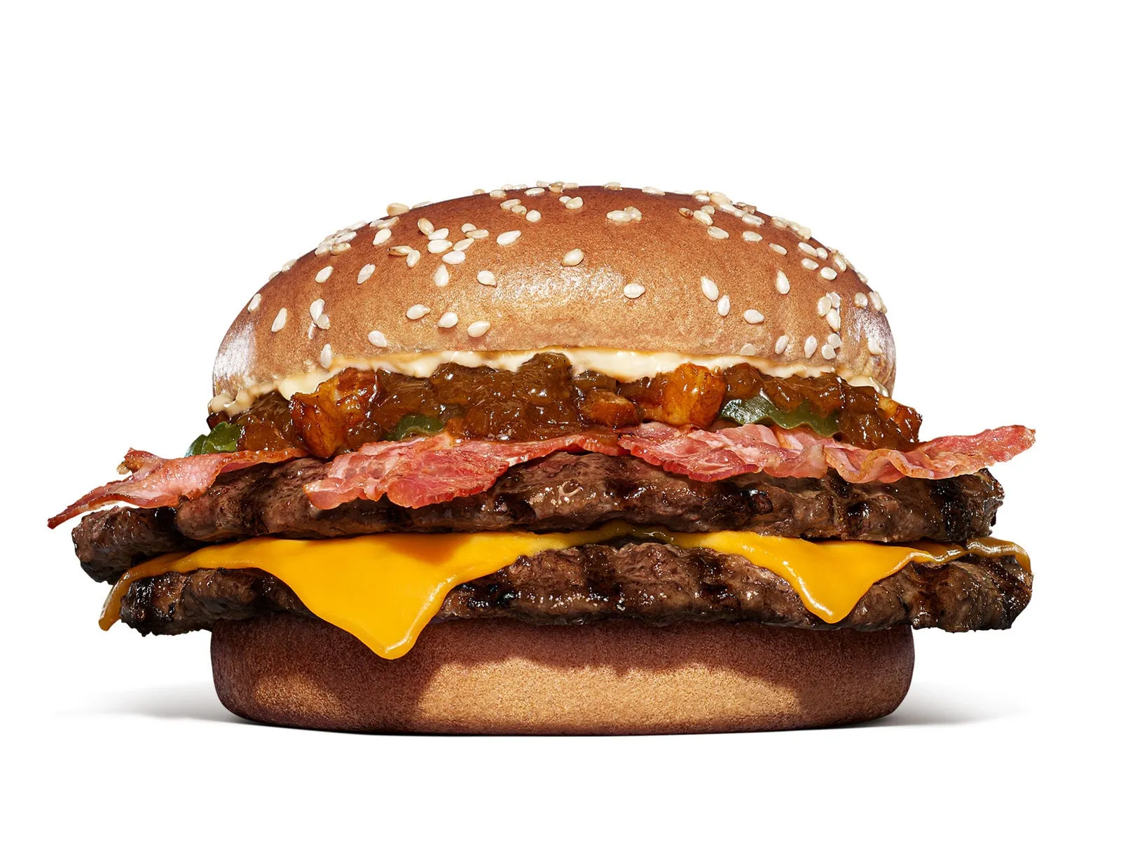 ハンバーガーのクローズアップ画像。2つのパティ、チーズ、ベーコン、チャツネ、ゴマのバンズが使用されています。