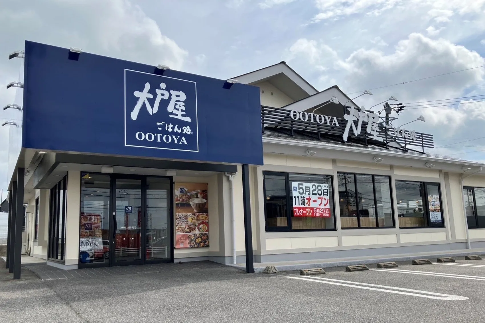大戸屋の店舗の外観写真。青い看板に店名が書かれており、オープン告知の看板も見える。
