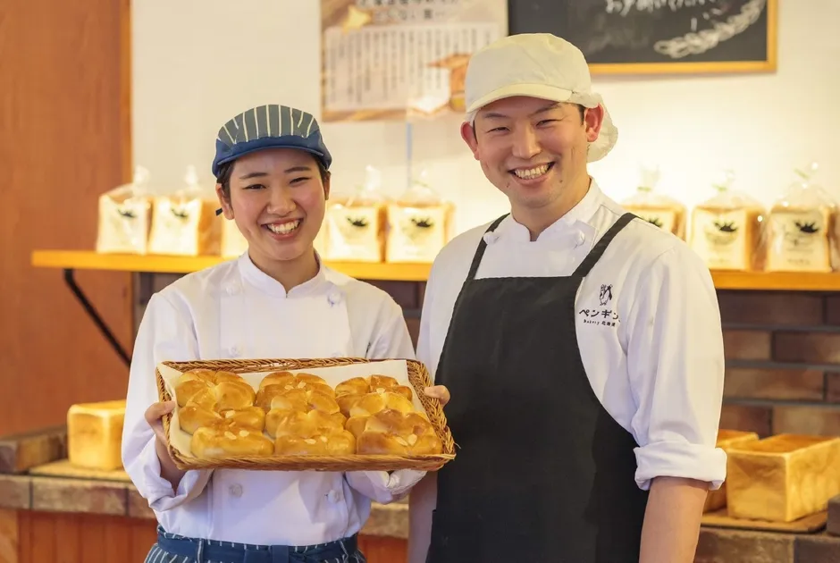 パン屋で笑顔でパンを持つ男女