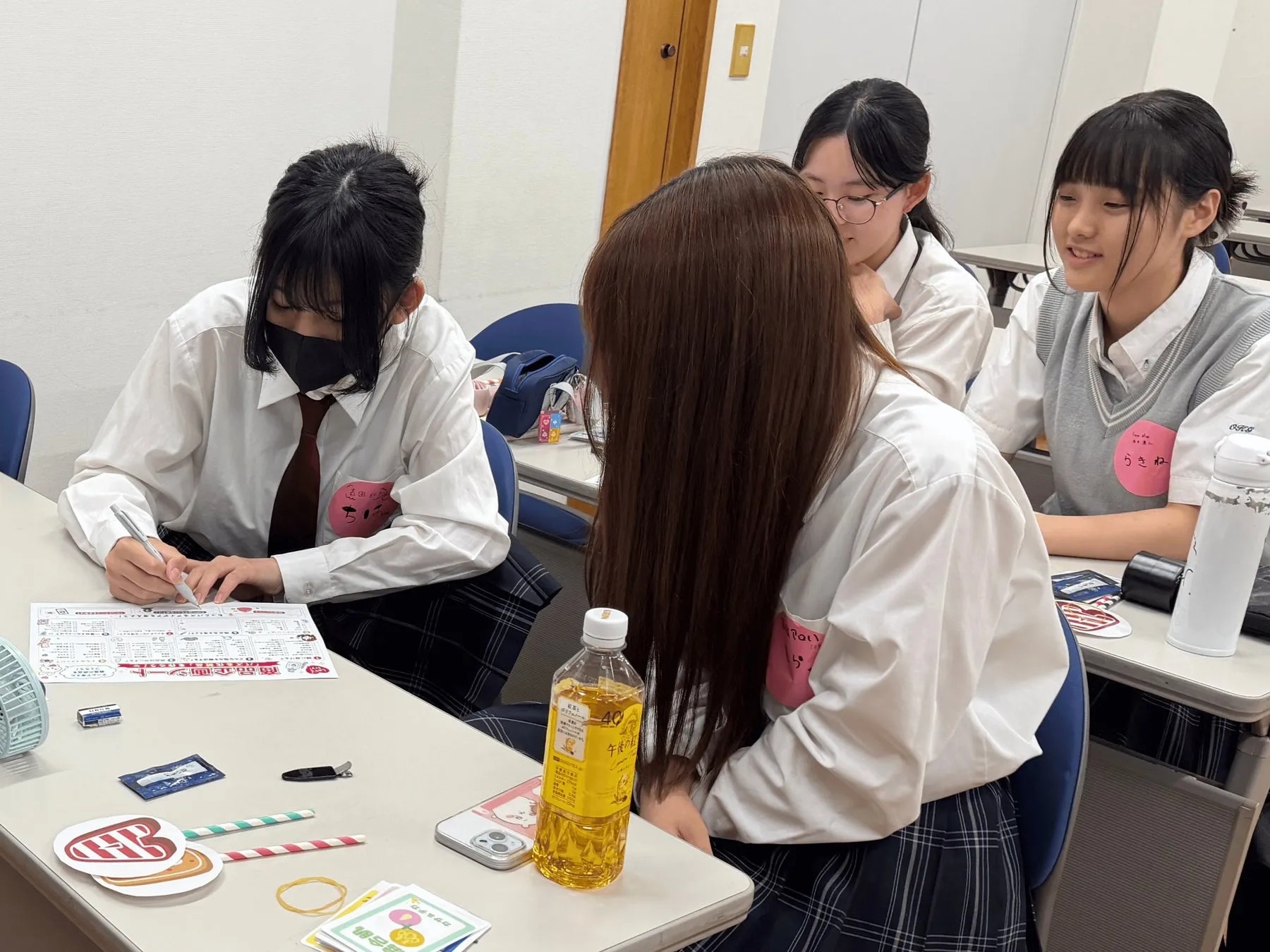 商品企画シートを手に話し合う生徒たち