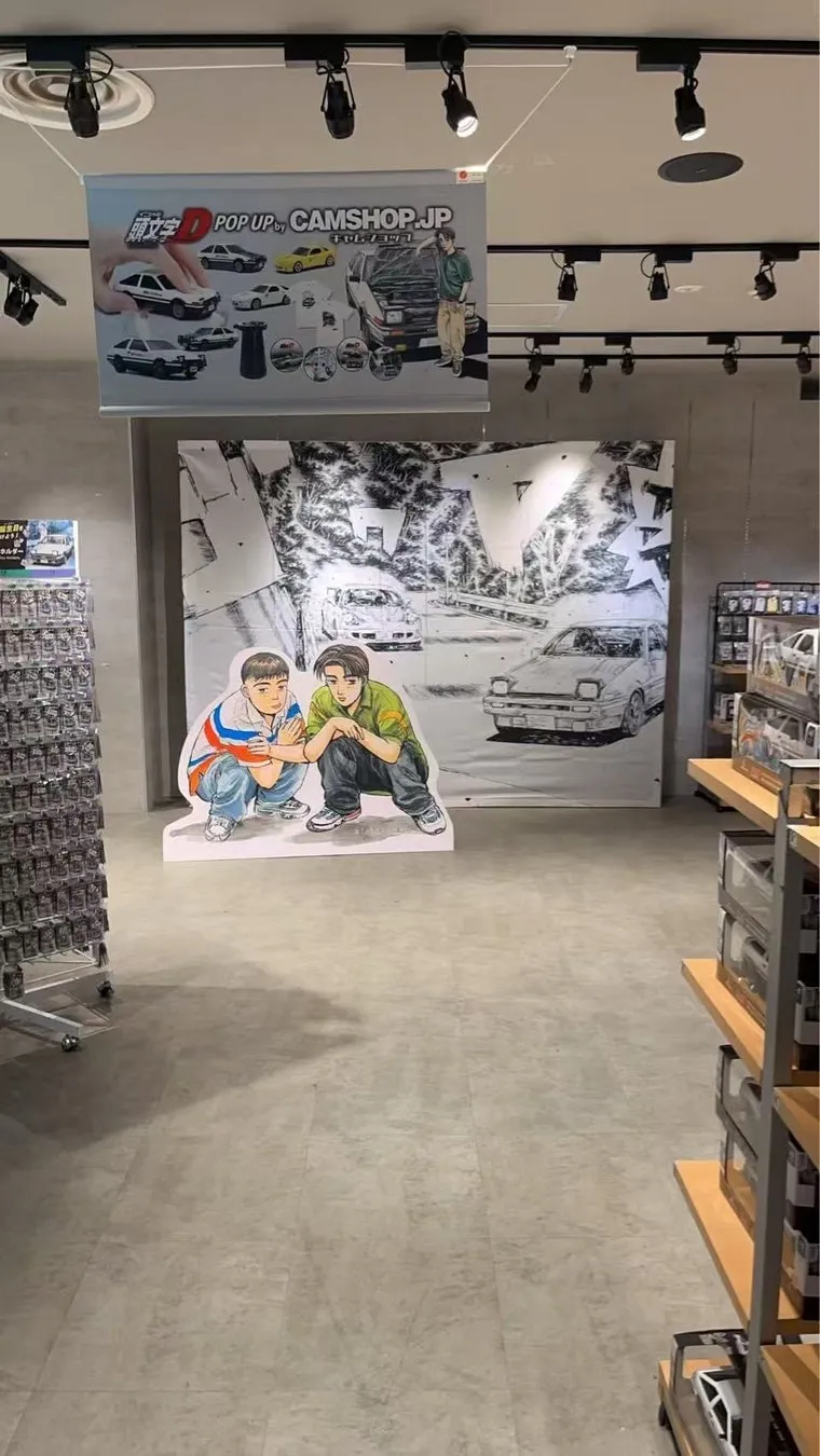 縦長のスマホ画面の動画/SNS投稿風の画像、藤原拓海の等身大パネルとAE86のフォトスポットを別角度から