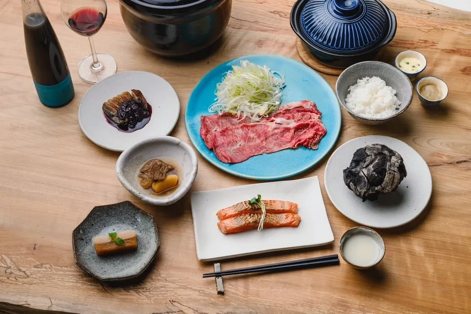 土鍋と肉、野菜、料理が並ぶ夕食