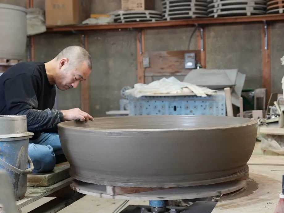 陶器の大きな浴槽を製作する職人