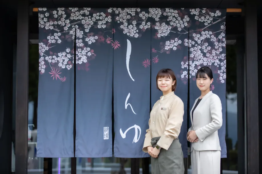上諏訪温泉しんゆの暖簾の前に立つスタッフ