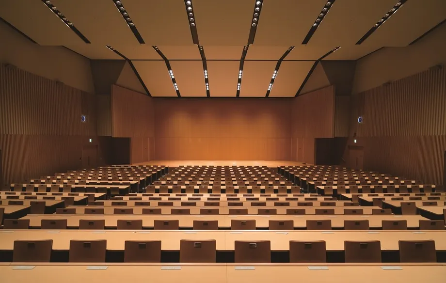 木調の壁と机、座席が並ぶ東京電機大学の丹羽ホール